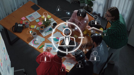 A diverse team gathers around a table in a modern office setting, engaged in collaboration, analysis, and strategic planning, showcasing teamwork and creativity. Rasterの写真素材