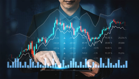 A businessman interacts with a tablet, showcasing financial charts and graphs, reflecting stock market trends and analysis for investment strategies and growth.の写真素材