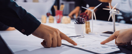 A dynamic business meeting in a modern office setting where team members collaborate on project plans, focusing on innovative and sustainable solutions for future growth.の写真素材