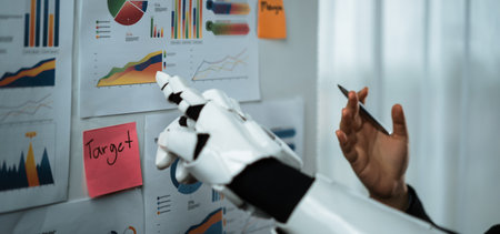 A robotic hand engages with various charts on the wall, showcasing modern analytics and data insights. This image embodies the fusion of technology and business strategy.の写真素材