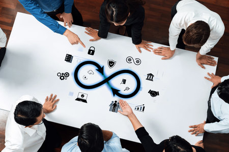 A diverse group collaborates around a table, engaging in strategic discussions symbolized by an infinity graphic and various digital icons, emphasizing growth and innovation.の写真素材