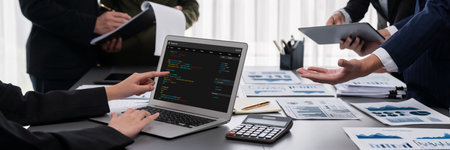 Panorama shot analyst team utilizing BI to analyze financial report with laptop. Businesspeople analyzing BI data dashboard displayed on laptop screen for business insight.の写真素材