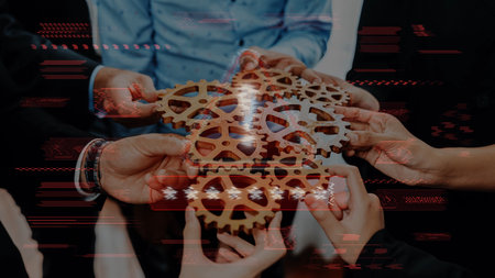 Hands come together to assemble wooden gears, symbolizing collaboration and innovation in a business environment focused on teamwork and strategic growth. Rasterの写真素材