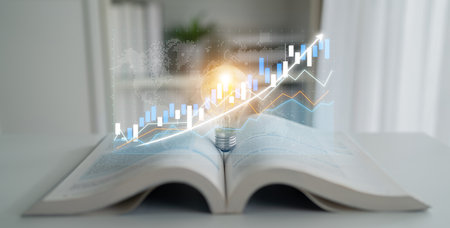 An open book with a glowing light bulb and digital graph illustrates concepts of growth, knowledge, and innovation in various sectors, perfect for educational or business use. Imputeの写真素材
