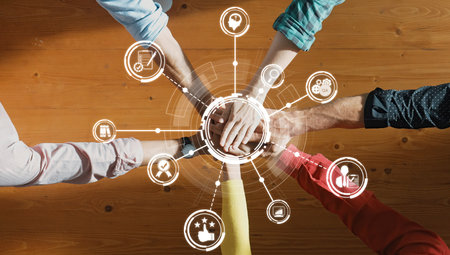 A top view of diverse hands joining together symbolizing collaboration and teamwork. Icons around highlight innovation and community connection, representing shared success and motivation. Amityの写真素材