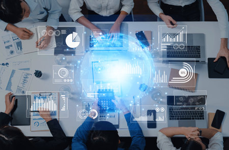 A top-down view of a business team engaged in data analysis with digital interfaces, showcasing charts and graphs to enhance strategic decision-making.の写真素材