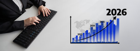 A business professional types on a keyboard while analyzing a projected growth graph showing...