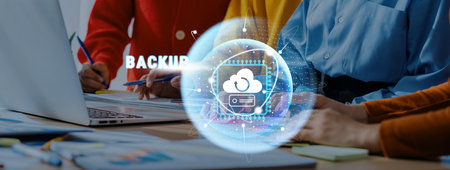 A diverse team of professionals collaborates on a cloud computing project, focusing on data backup and security with modern tools in a contemporary office setting.の写真素材