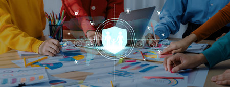 A diverse team engages in a collaborative discussion about data security strategies. The scene features charts and visual aids, emphasizing teamwork and digital protection.の写真素材