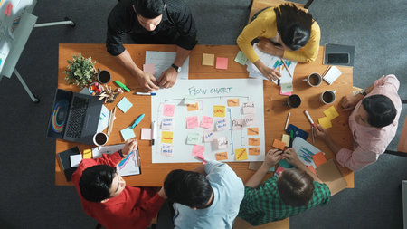 Top down aerial view of professional business people hands making scrum task board to manage workflow in workplace. Diverse smart team shaking hand and making agreement at meeting room.の写真素材