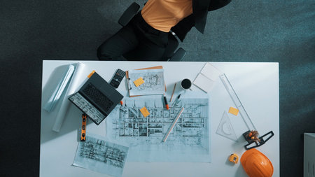 Top view of relaxed smart civil engineer lie on chair at table with blueprint in break time. Aerial...