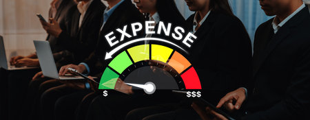 A group of business professionals analyze expense levels using a meter gauge in an office. This setting highlights the importance of financial planning and smart decision-making.の写真素材