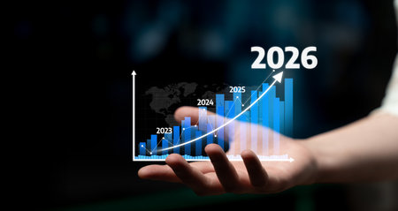 A hand holding a futuristic bar graph representing business growth forecasts from 2023 to 2026. This...