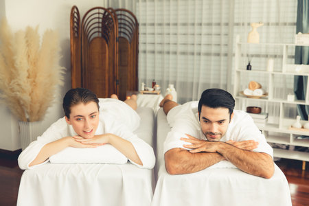 Caucasian couple customer enjoying relaxing anti-stress spa massage and pampering with beauty skin recreation leisure in day light ambient salon spa at luxury resort or hotel. Quiescentの写真素材