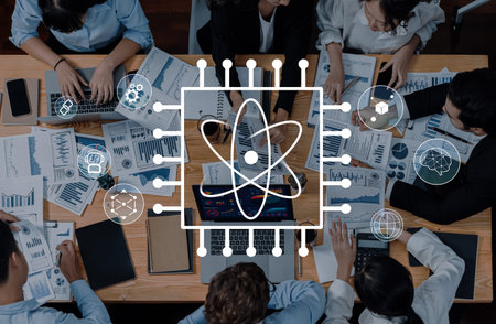 A diverse team engages in a collaborative meeting, analyzing data and strategizing while utilizing technology, charts, and documents in a modern office environment.の写真素材