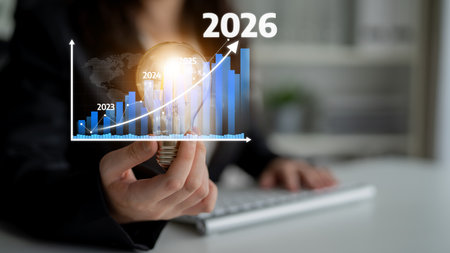 A business professional analyzes future growth potential with a light bulb idea and graph while projecting success towards the year 2026 in an office setting. Tesselの写真素材