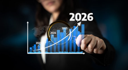 A professional businesswoman presents a growth chart with future projections for 2026, highlighting upward trends and potential market success in a corporate environment. Tesselの写真素材