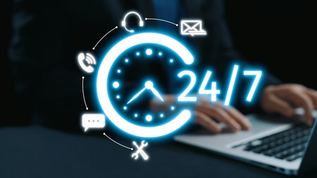 A businessman engaging with a laptop in a dark setting, featuring a glowing 24 hour service concept and digital icons, symbolizing constant availability and efficient communication.の写真素材