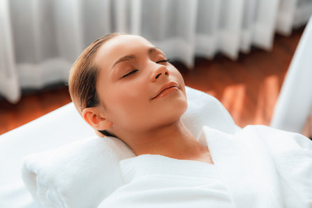 Caucasian woman customer enjoying relaxing anti-stress spa massage and pampering with beauty skin recreation leisure in day light ambient salon spa at luxury resort or hotel. Quiescentの写真素材