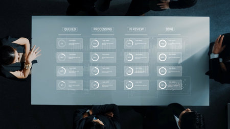 A modern meeting setup featuring a table with a digital display that illustrates project status and workflow, highlighting collaboration and data-driven decision-making. Rasterの写真素材