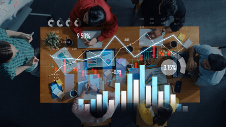 Aerial view of a diverse team engaged in data analysis using charts and graphs, showcasing collaboration in decision-making and strategic planning for business success.の写真素材