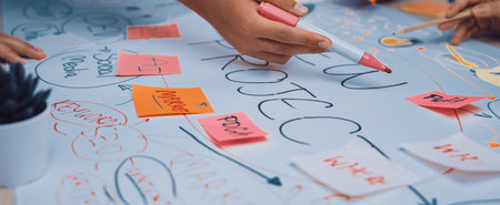 Hands engaged in a vibrant brainstorming session, surrounded by colorful sticky notes and a large...