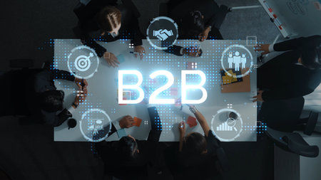 Aerial view of a business meeting showcasing teamwork and collaboration with the B2B concept illustrated through digital graphics in a modern office environment. Rasterの写真素材