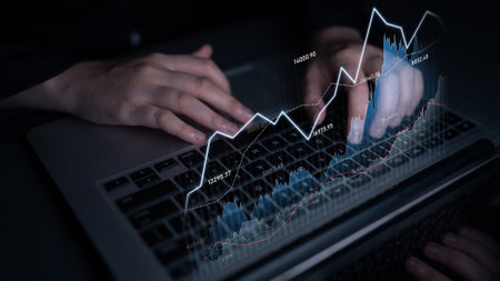 A business professional analyzes financial data on a laptop, showcasing dynamic graphs and charts that illustrate stock market trends and analytics.の写真素材