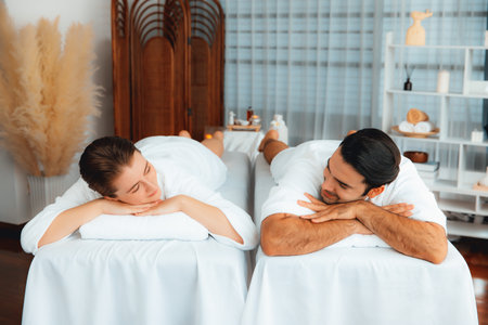 Caucasian couple customer enjoying relaxing anti-stress spa massage and pampering with beauty skin recreation leisure in day light ambient salon spa at luxury resort or hotel. Quiescentの写真素材