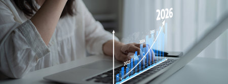 A business professional engages with a laptop, analyzing financial growth trends through a visual...