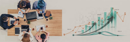 Diverse business team collaborates around table, analyzing data and charts, fostering an environment of teamwork and innovation for successful project execution and strategy development.の写真素材