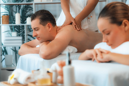 Caucasian couple customer enjoying relaxing anti-stress spa massage and pampering with beauty skin recreation leisure in day light ambient salon spa at luxury resort or hotel. Quiescentの写真素材