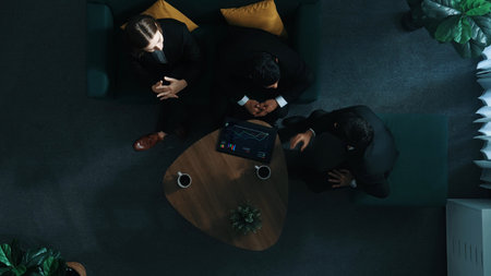 Top down aerial view of business people making agreement about collaborate business and shaking hands. Diverse group show tablet with financial statistic on table while explain plan. Directorate.の写真素材