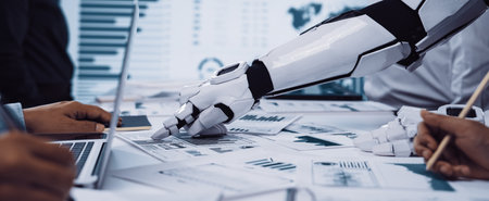 A futuristic robotic hand interacts with human colleagues in a sleek workspace, showcasing collaboration through data presentation and analysis with charts and graphs.の写真素材