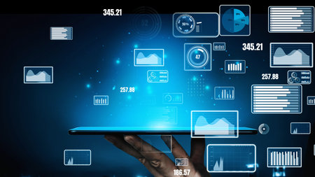 A digital tablet held in hand displays futuristic graphs and charts, representing innovative data visualization concepts for business analytics and technology advancements.の写真素材