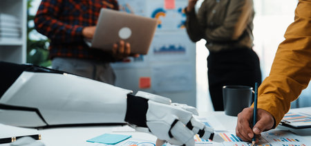 A human and a robot collaborate in a contemporary office setting. The scene highlights innovative teamwork and creative problem solving through technology, showcasing tools and ideas.の写真素材