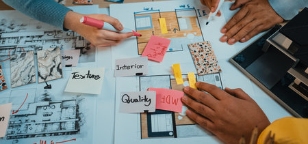 Professionals collaborate on architectural plans and design ideas, using color swatches and notes in a dynamic brainstorming session to create innovative spaces.の写真素材