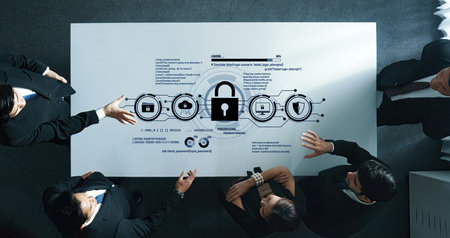 A professional business team collaborates to discuss data security strategy using a digital interface on a modern office table, highlighting teamwork and innovation.の写真素材