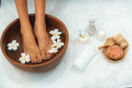 Panorama top view woman indulges in blissful foot massage at luxurious spa salon while masseur give reflexology therapy in gentle day light ambiance resort or hotel foot spa. Quiescentの写真素材