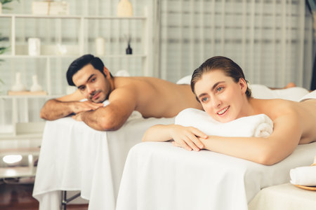 Caucasian couple customer enjoying relaxing anti-stress spa massage and pampering with beauty skin recreation leisure in day light ambient salon spa at luxury resort or hotel. Quiescentの写真素材