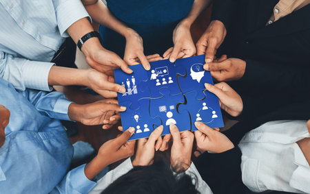 A diverse group of individuals collectively working on a puzzle featuring business icons,...