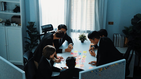 Top view of business team brainstorm marketing idea by using sticky notes. Group of diverse startup people planning financial strategy while sitting and writing a note at meeting table. Directorate.の写真素材
