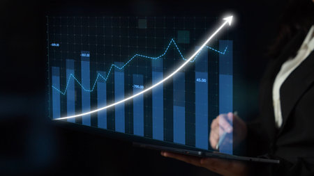 A professional businesswoman analyzes data on a laptop, showcasing a bar chart with an upward trend,...