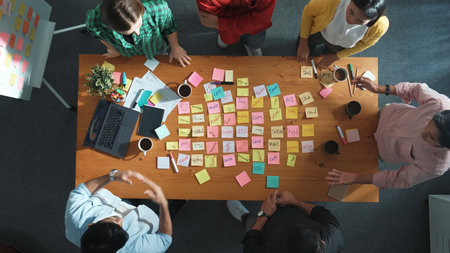 Top down view of smart diverse business people writing marketing idea at meeting and brainstorming start up project strategy or campaign at meeting room. Creative group discussing plan. Convocation.の写真素材