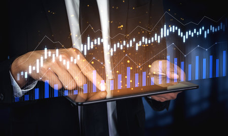 Business professional interacts with a digital tablet, analyzing financial data through modern graphs and charts to enhance decision-making in a corporate setting.の写真素材