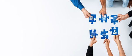 This image captures a diverse team collaborating with puzzle pieces, symbolizing teamwork and...