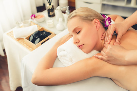 Caucasian woman customer enjoying relaxing anti-stress spa massage and pampering with beauty skin recreation leisure in day light ambient salon spa at luxury resort or hotel. Quiescentの写真素材