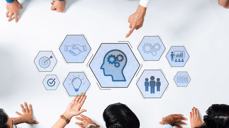 A diverse business team engages in a collaborative discussion over a table surrounded by conceptual icons symbolizing knowledge, creativity, and teamwork for innovative strategies. Rasterの写真素材