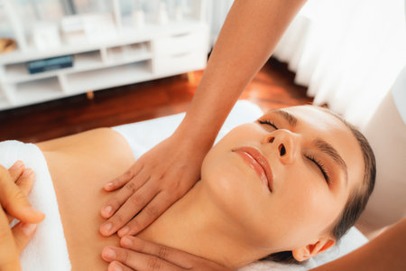 Caucasian woman customer enjoying relaxing anti-stress spa massage and pampering with beauty skin recreation leisure in day light ambient salon spa at luxury resort or hotel. Quiescentの写真素材