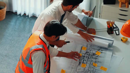 Top view of project manager and civil engineer holding laptop while explaining idea to architect....
